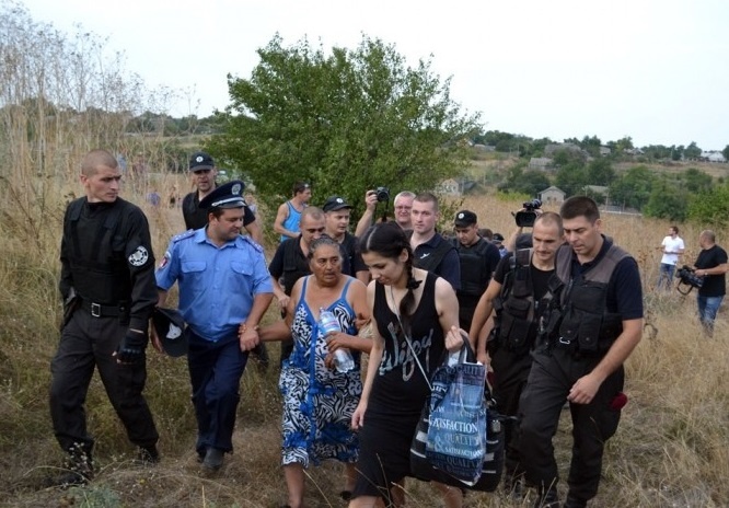 Правоохоронці виводять ромів Лощинівки після погромів, які влаштували місцеві селяни (фото: izbirkom.org.ua)